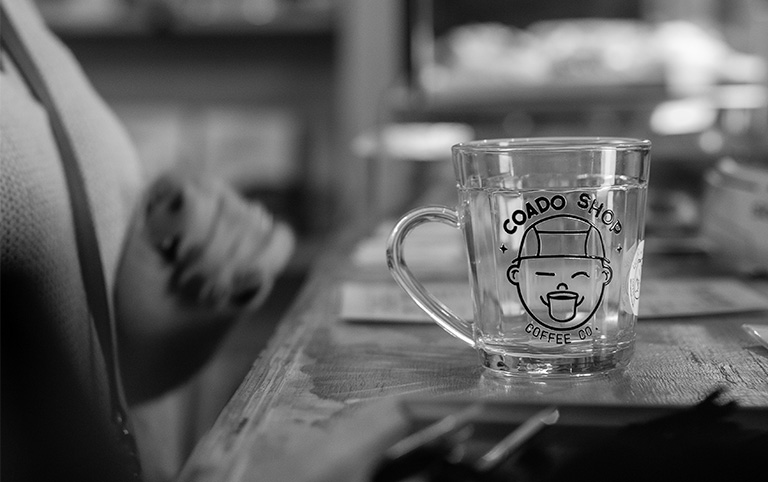 Fotografia colorida de um copo do Coado Shop Coffee Co. - Coado Shop Café - por Diogo França - @difgomez