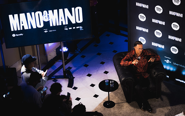 Fotografia colorida do Mano Brown no palco do Mano a Mano no Museu das Favelas por Isabelle India - Spotify