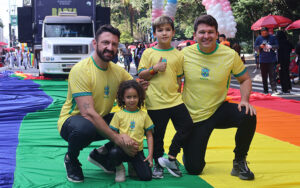 Fotografia colorida de pais e crianças na Parada do Orgulho LGBT+ em São Paulo - divulgação Acervo ParadaSP